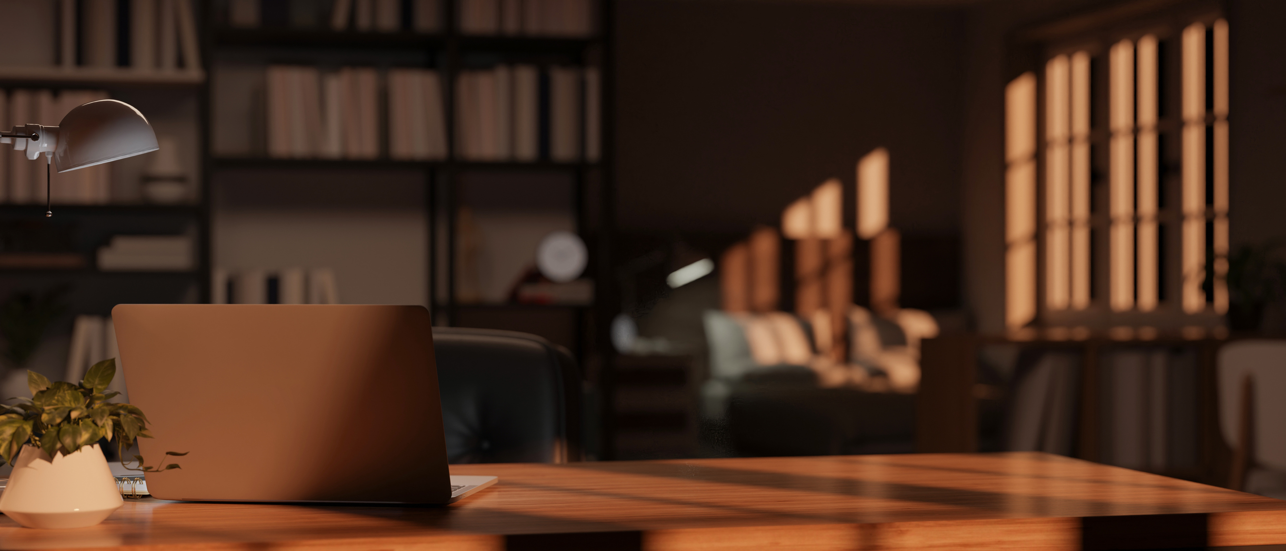 A warm, after-hours study with a laptop on a wooden desk